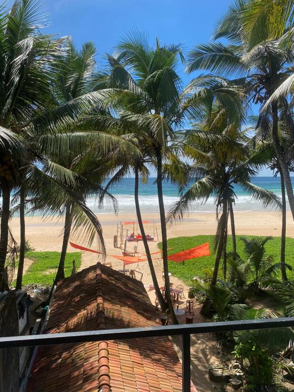 - une vue sur la plage bordée de palmiers et l'océan dans l'établissement Heimat Hugs, à Habaraduwa Central