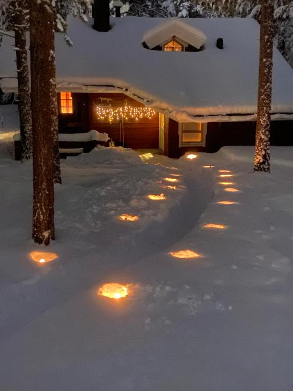 uma casa coberta de neve com luzes na neve em Hukka, 4+3 hlö, Levi em Levi