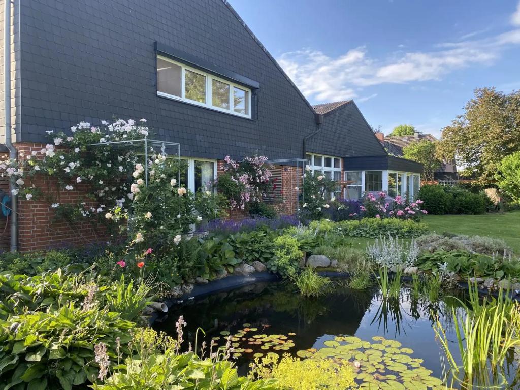 un jardín con un estanque frente a una casa en Landhaus Bleckede - App 2 Lüneburg, en Bleckede