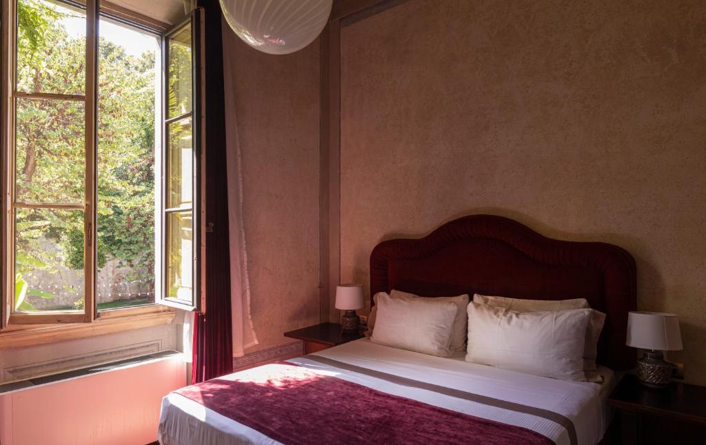 1 dormitorio con 1 cama y 2 ventanas en Palazzo San Niccolò en Florencia