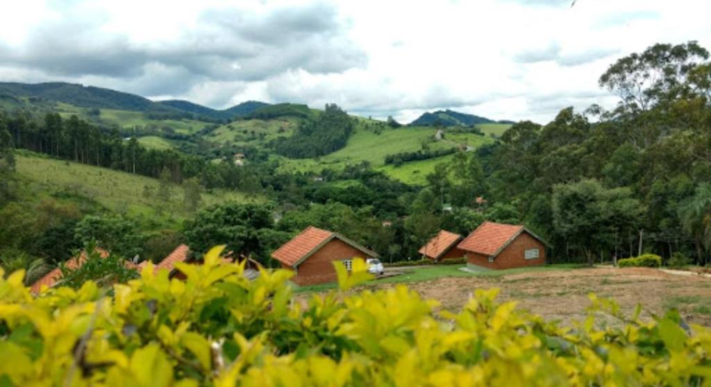 a group of houses on a hill in a field at Pousada Ecológica Rio do Peixe in Socorro