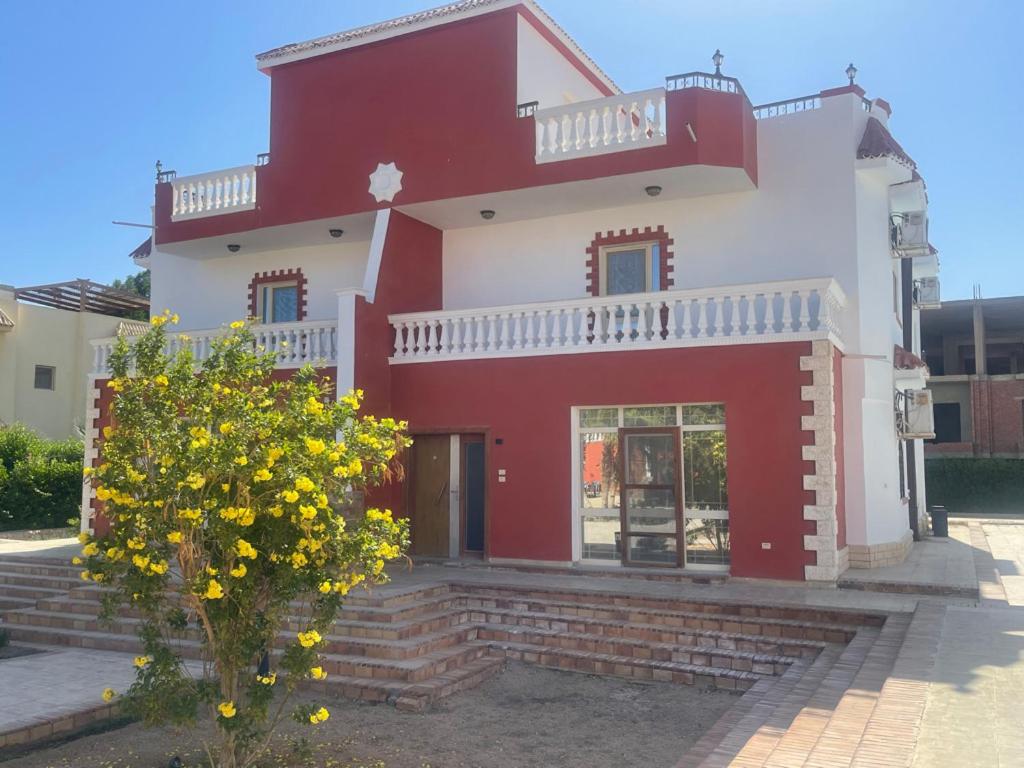 赫尔格达Hurghada-Magawish Villa 6的前面有树的红白房子