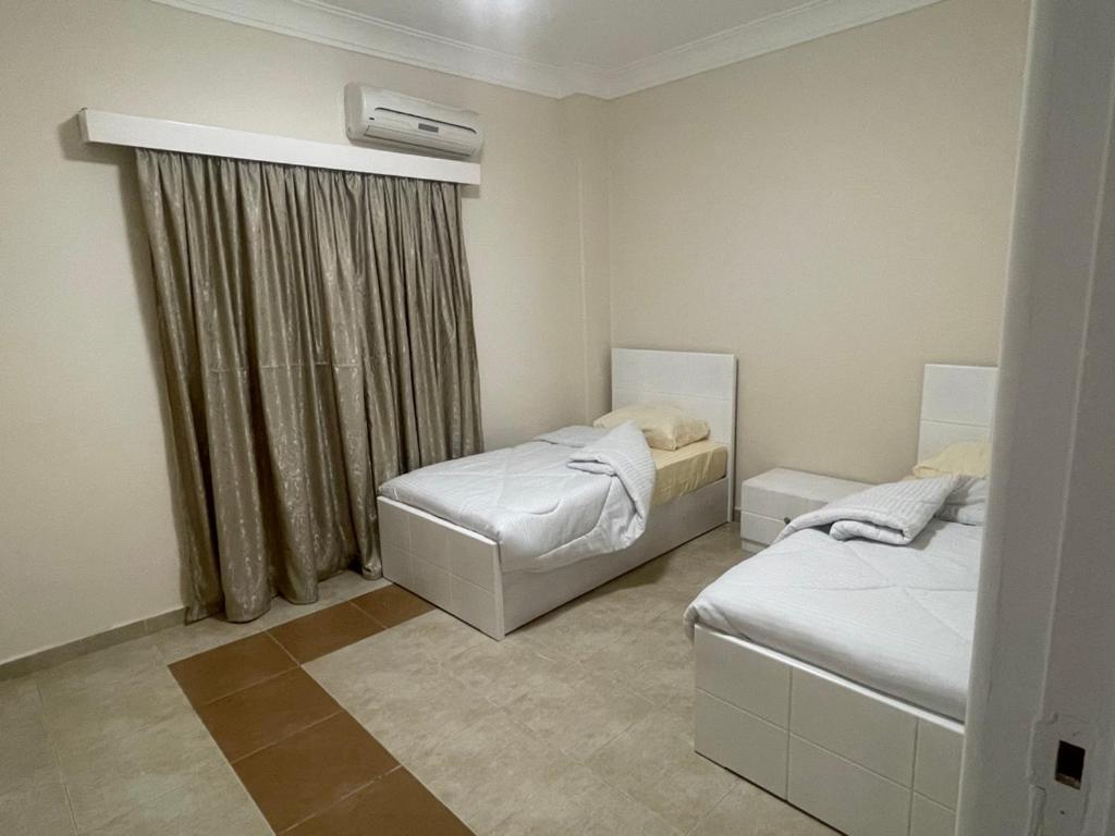 een slaapkamer met 2 bedden en een raam bij Moubark 6 Villa 6 in Hurghada