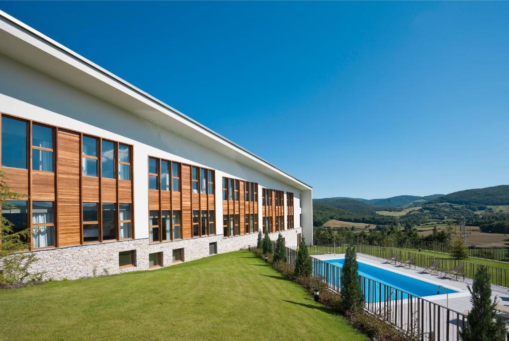 an external view of a building with a swimming pool at Hotel & Spa El Mirador de Ulzama in Urrizola-Galáin