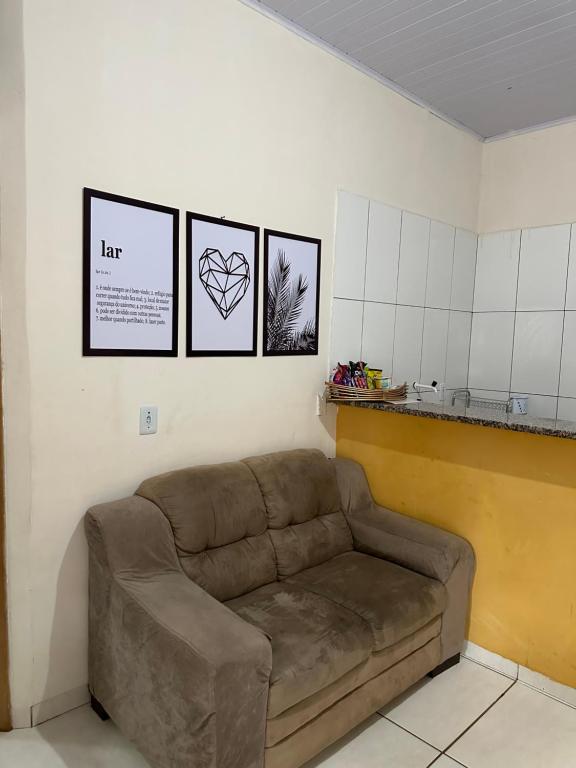 um sofá num quarto com três fotografias na parede em Recanto Sonho - PX Palmas Brasil em Palmas