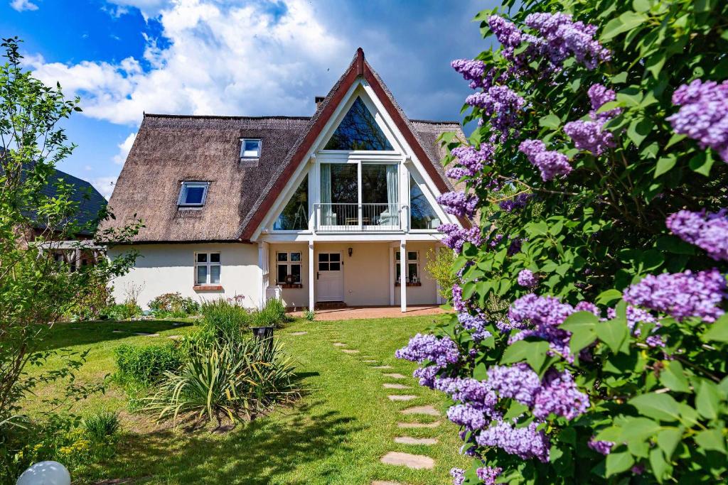 a house with a large window and purple flowers at Ferienhaus Schwalbenhof Lieper Winkel, Rankwitz in Grüssow