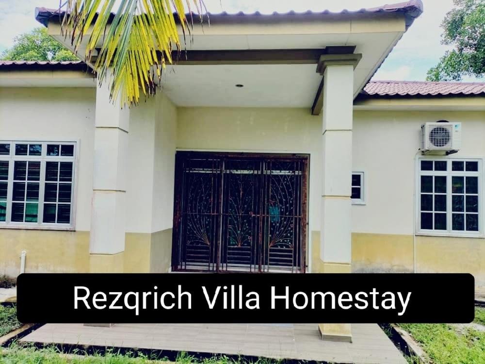 una casa con una puerta delante de ella en Rezqrich Villa Homestay 2, en Kampung Degong