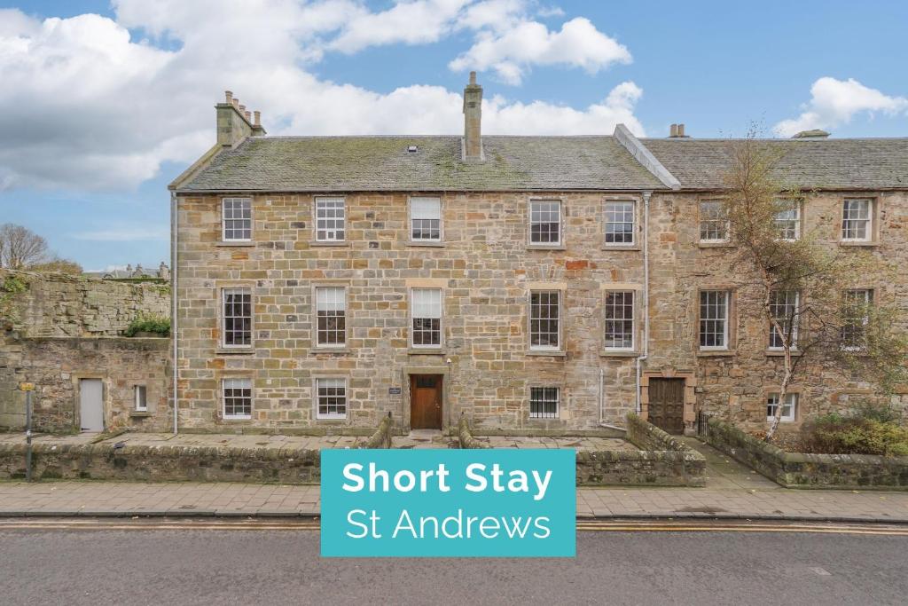 an old brick building with a sign that says short stay st ambassadors at Priorsgate in St Andrews