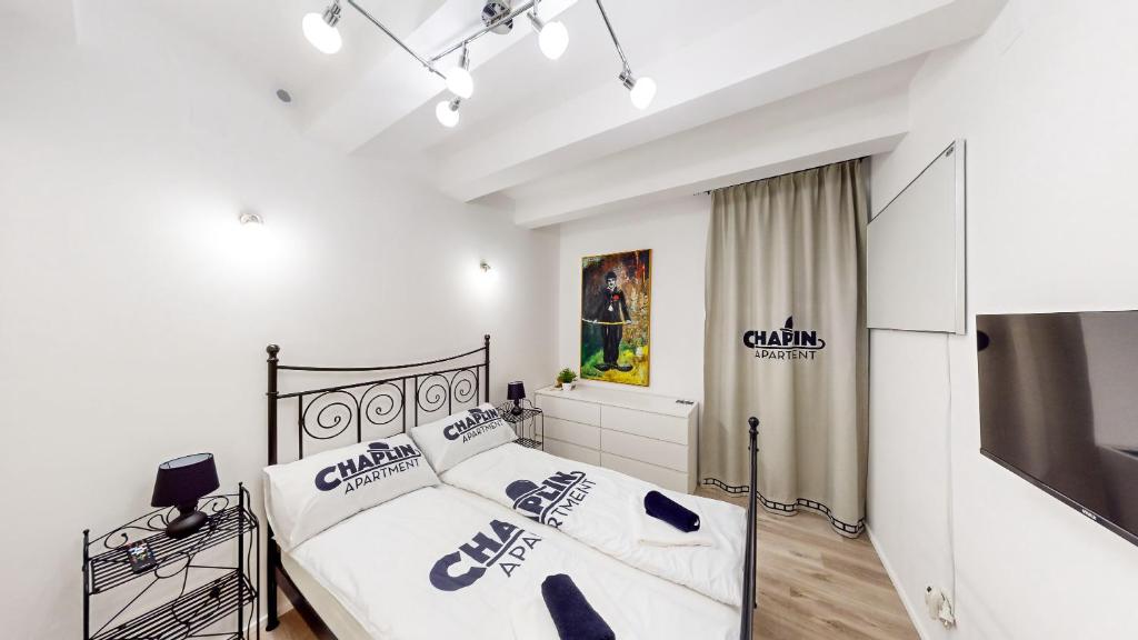 1 dormitorio con 2 camas y TV. en Chaplin Apartment - Free Garage Parking, en Liubliana