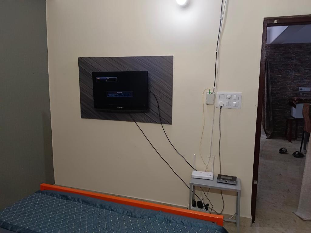 pared con TV en el lateral de una habitación en Eastern guest house, en Patna