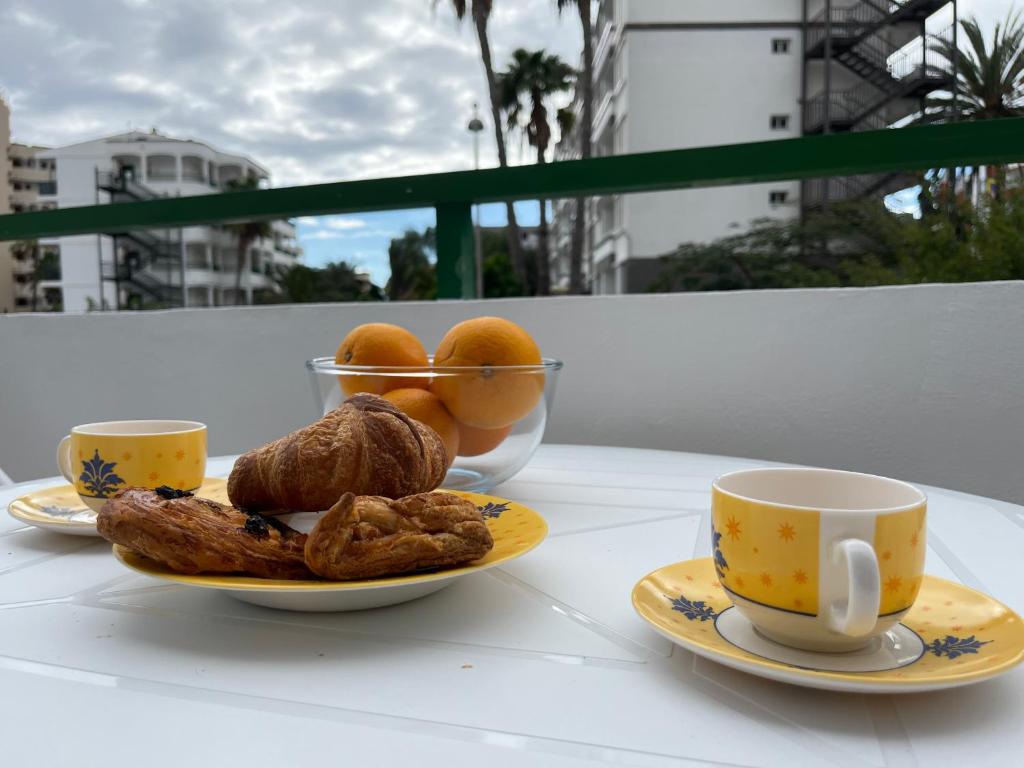 a table with two cups and a plate of food at Playa Ingles central cozy apartment in Maspalomas