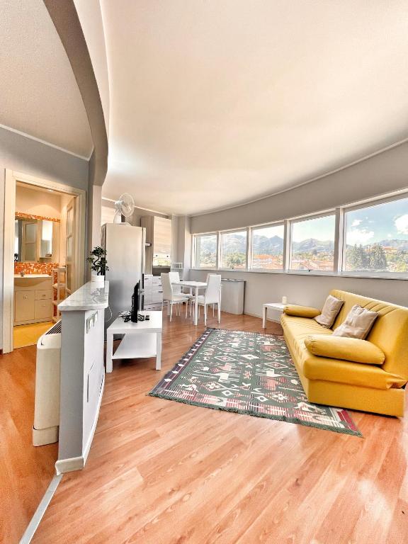 a living room with a yellow couch and a kitchen at L'Appartamentino Montagna in Biella