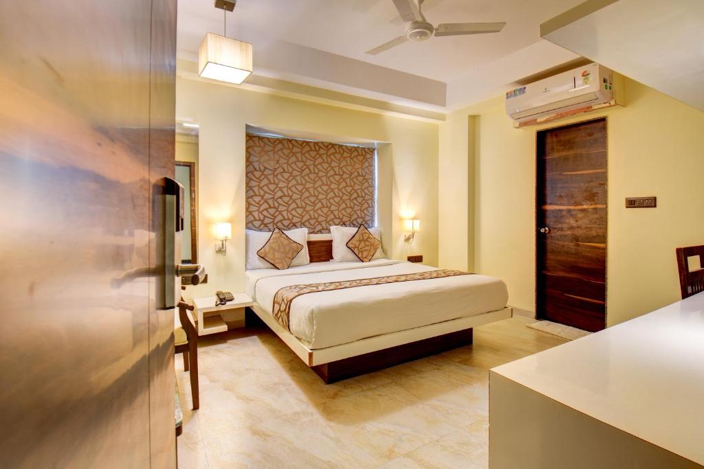 a hotel room with a bed and a kitchen at Hotel Deepali Executive in Aurangabad
