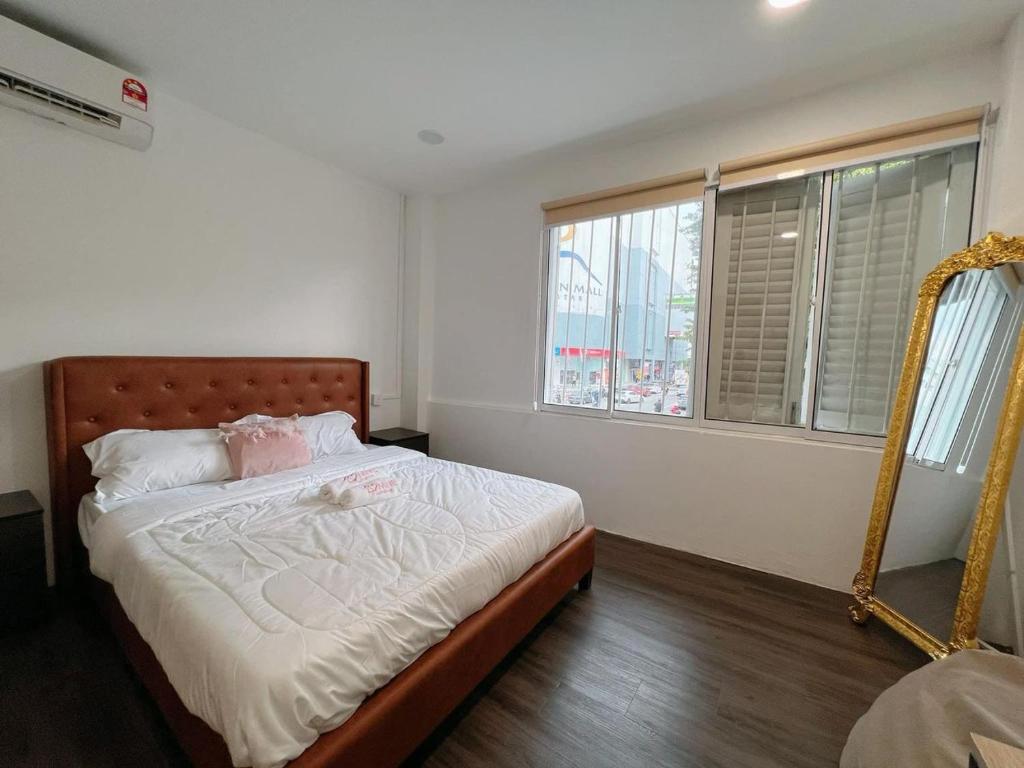 een slaapkamer met een bed met een spiegel en ramen bij Penang Heritage Home in George Town