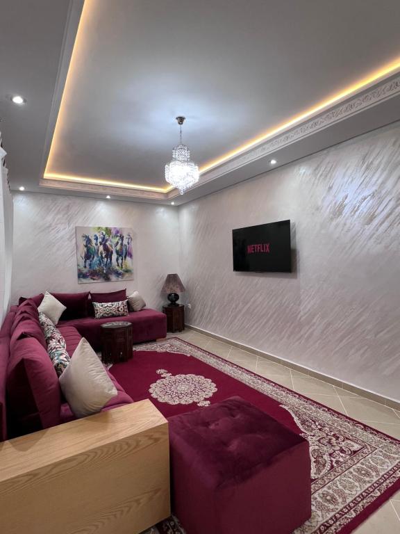 sala de estar con sofá y TV en Kenitra Unique Design Appartment, en Kenitra