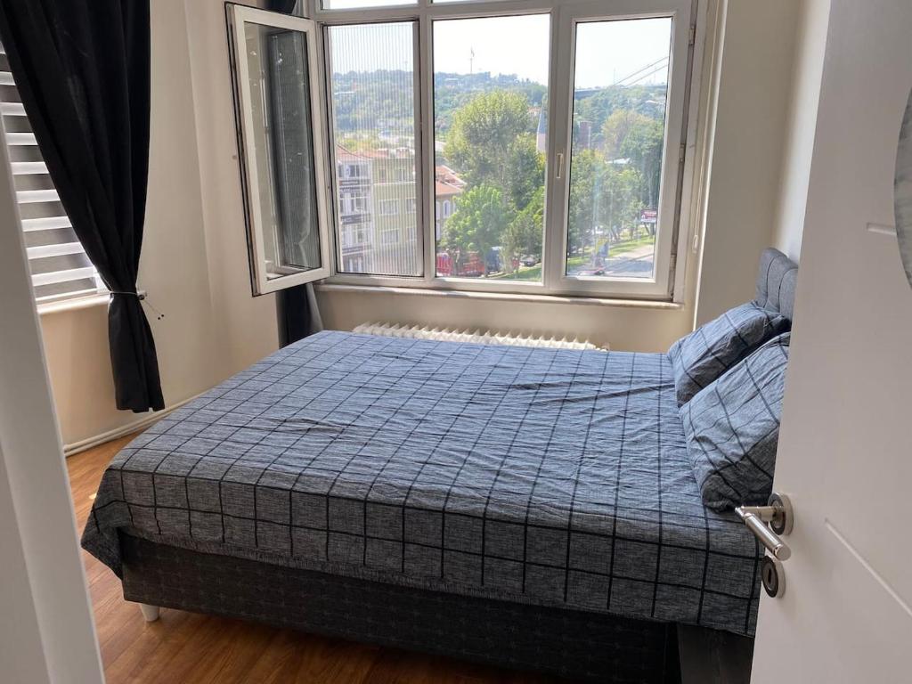 1 dormitorio con 1 cama frente a una ventana en Best Bosphorus View Entire 2 Bedroom Flat, en Estambul