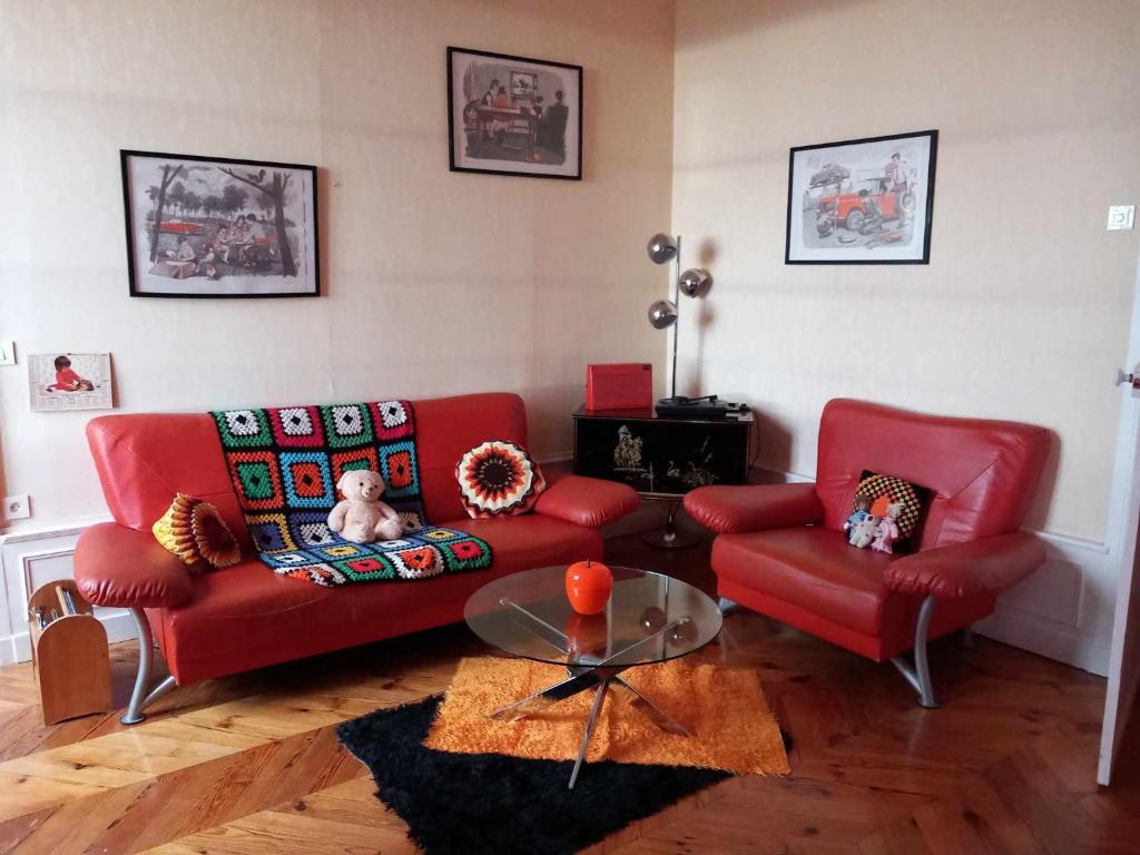 a living room with a red couch and two chairs at Vintage ,le paradis des enfants wifi draps parking free in Thiers