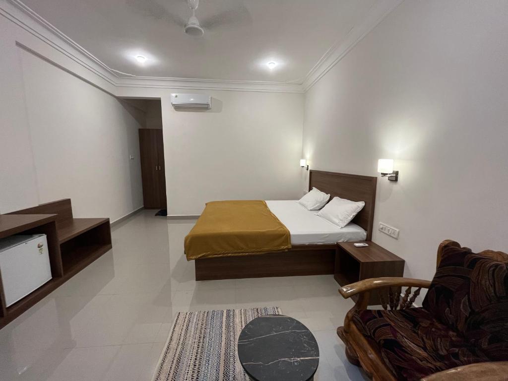 een slaapkamer met een bed en een tv en een bank bij Morjim Sunset Guesthouse - 300 meter to Morjim Beach in Morjim