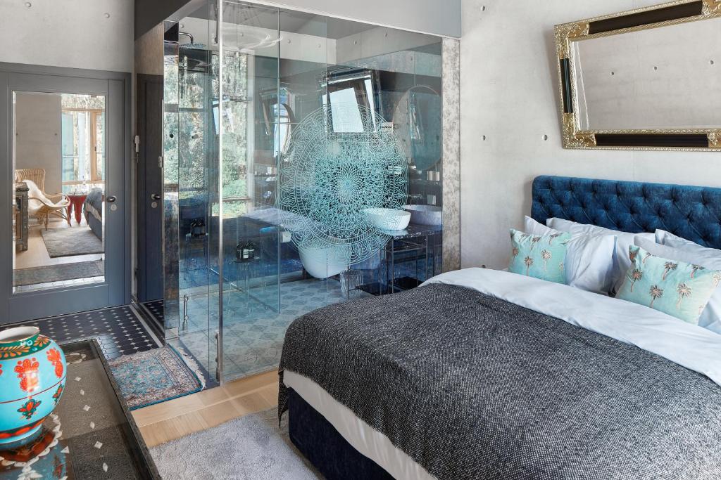 a bedroom with a blue bed and a glass shower at Ola Foundation Residence in Rīga