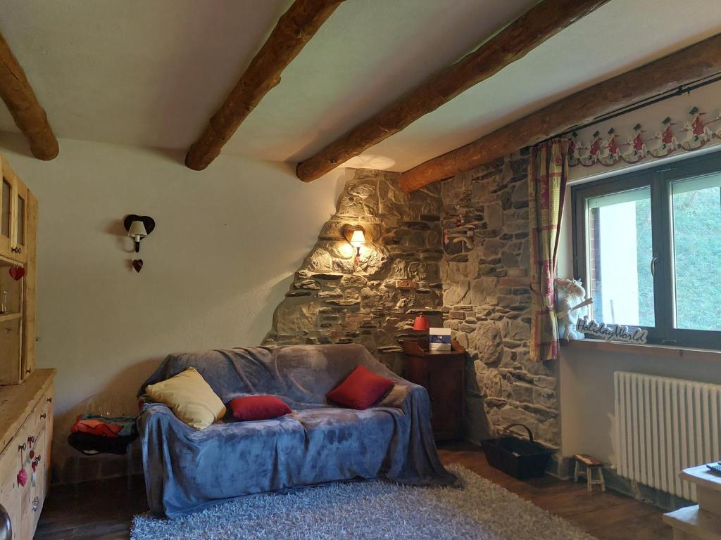 sala de estar con sofá en una pared de piedra en Casa Ale by Holiday World en Limone Piemonte