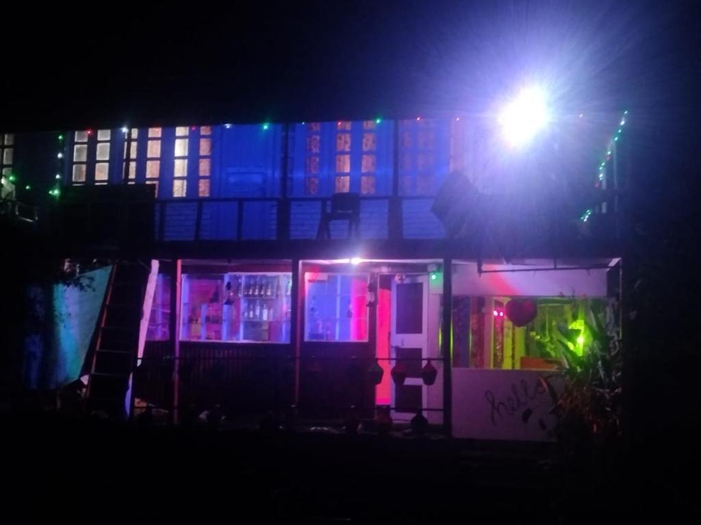 - un bâtiment avec des lumières colorées la nuit dans l'établissement Trishul Cafe, à Tosh