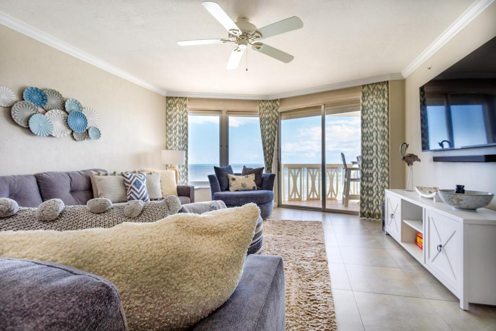 a living room with a couch and a tv at Paloma Penthouse in Ormond Beach