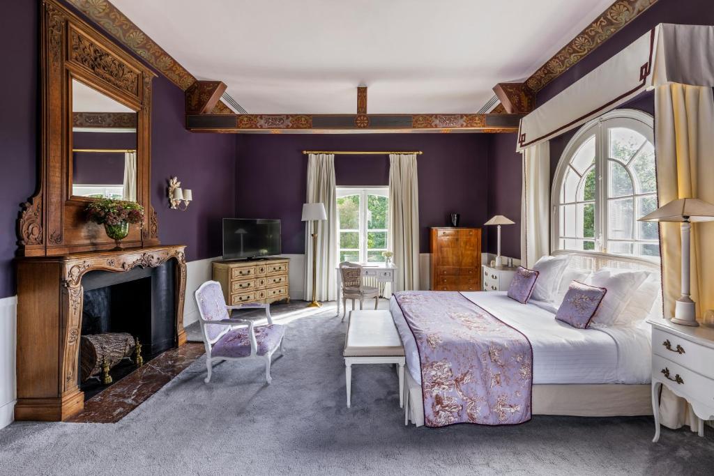 a bedroom with a king sized bed and a fireplace at Les Hauts de Loire in Onzain