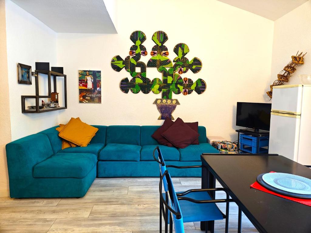 a living room with a blue couch and a table at Hostdomus - Sansicario R19 in Cesana Torinese