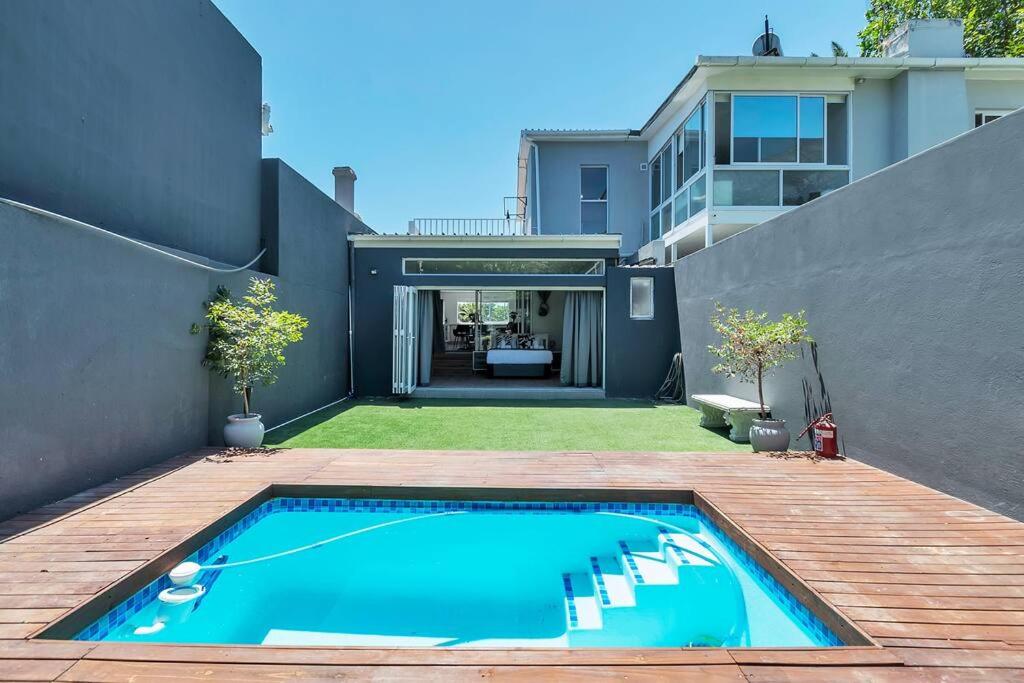 een achtertuin met een zwembad en een huis bij Two Bedroom House with Views of Lions Head in Kaapstad