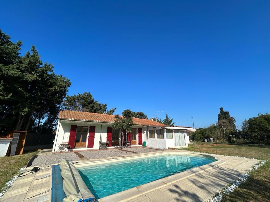 uma casa com uma piscina em frente em Maison Elne, 5 pièces, 10 personnes - FR-1-732-60 em Elne