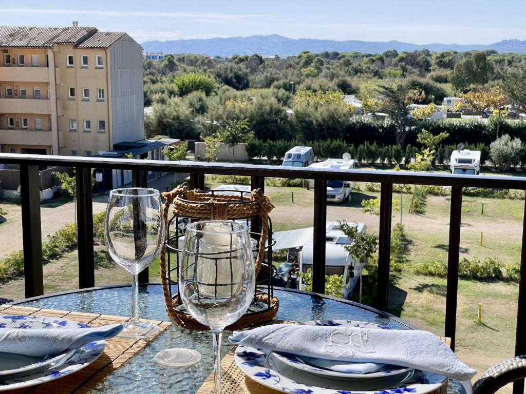 a table with two wine glasses on a balcony at JARDINS DEL MAR 114 in L'Estartit