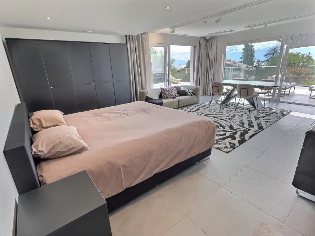 1 dormitorio con 1 cama grande y comedor en Attica Résidences, Lausanne, en Saint-Sulpice