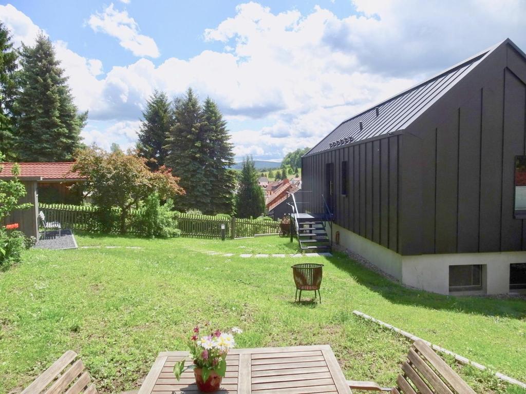 a black barn with a picnic table in a yard at Alte Tischlerei Engelsbach in Georgenthal