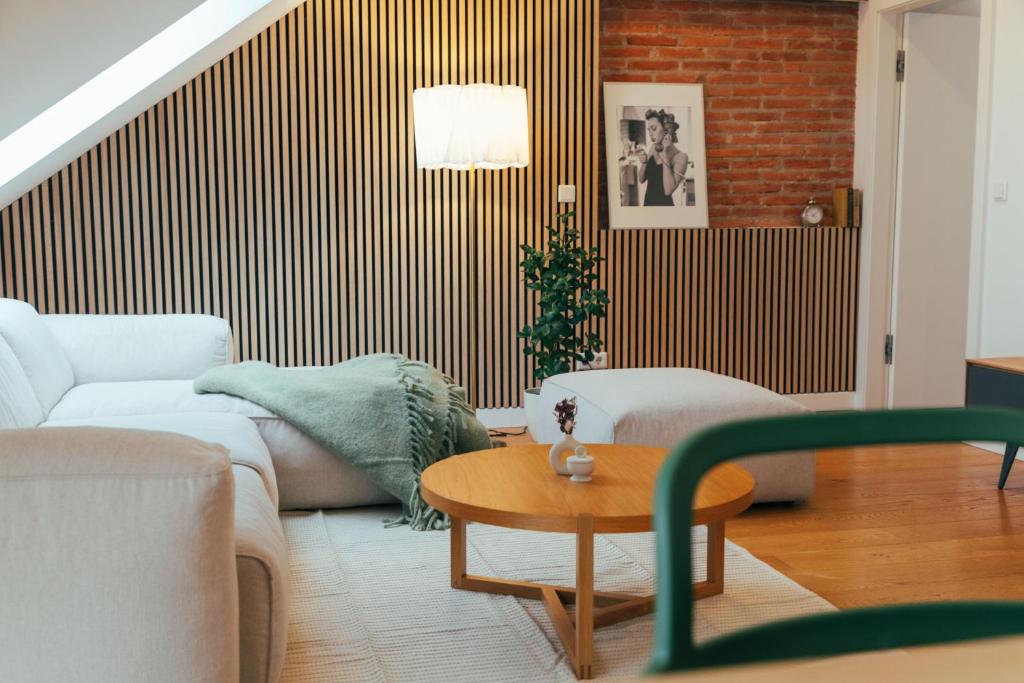 Large Apartments - Great for Groups - with Balcony or Terrace في فيينا: غرفة معيشة مع أريكة وطاولة