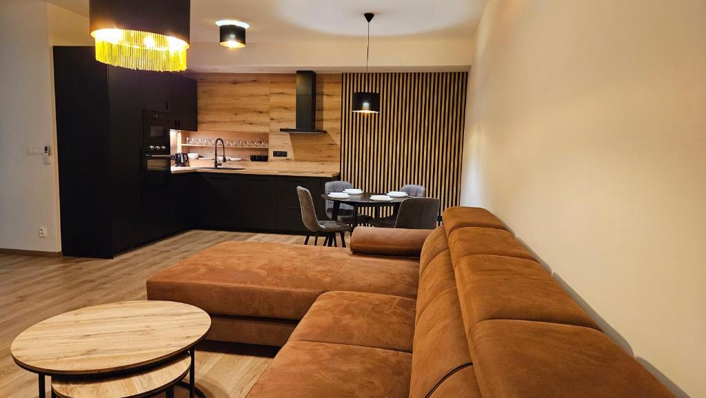 sala de estar con sofá marrón y mesa en Apartmán PROMENÁDA en Nitra