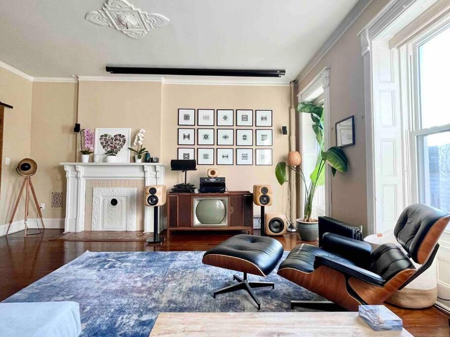 ein Wohnzimmer mit einem TV, einem Sofa und Stühlen in der Unterkunft Relaxing & cozy SPA. apt in Brooklyn mins to MHTN in Brooklyn