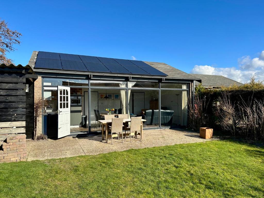 a conservatory with a table and chairs in a yard at Boerenslag 42 in Sint Maartensvlotbrug