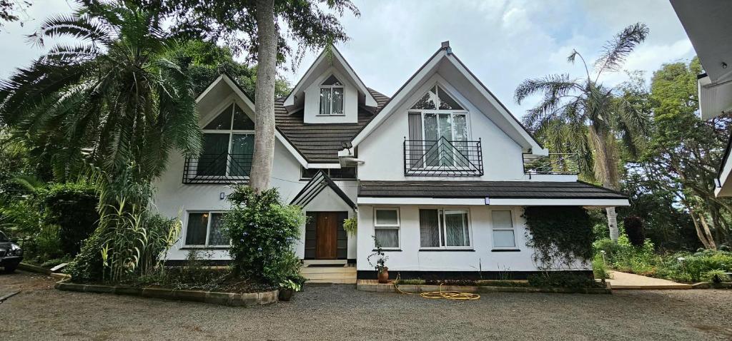 ein weißes Haus mit einer Palme davor in der Unterkunft Diplomatic Short Stay in Gigiri in Nairobi