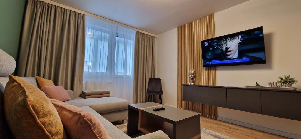 un soggiorno con divano e TV a parete di CENTRAL 6 a Topliţa