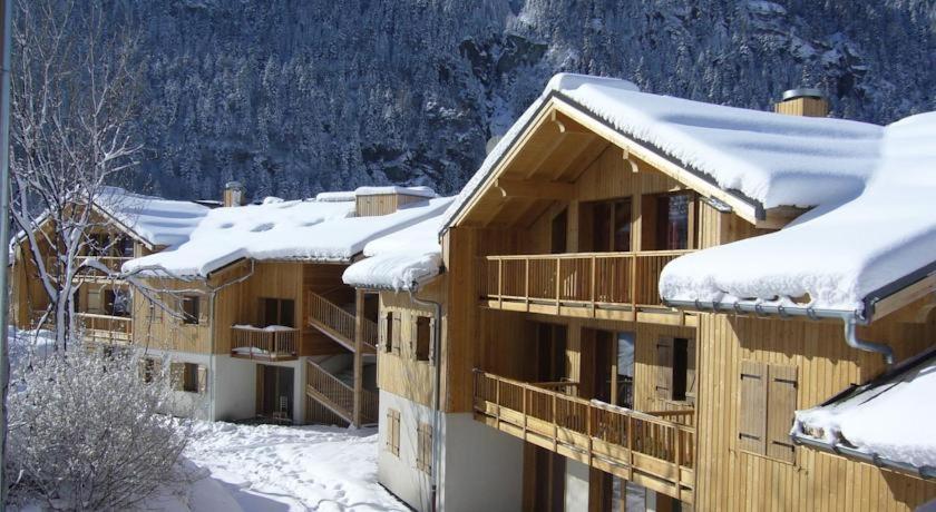 un edificio cubierto de nieve con techos nevados en Orelle 3 Vallées - 2 pièces 6 personnes, en Orelle