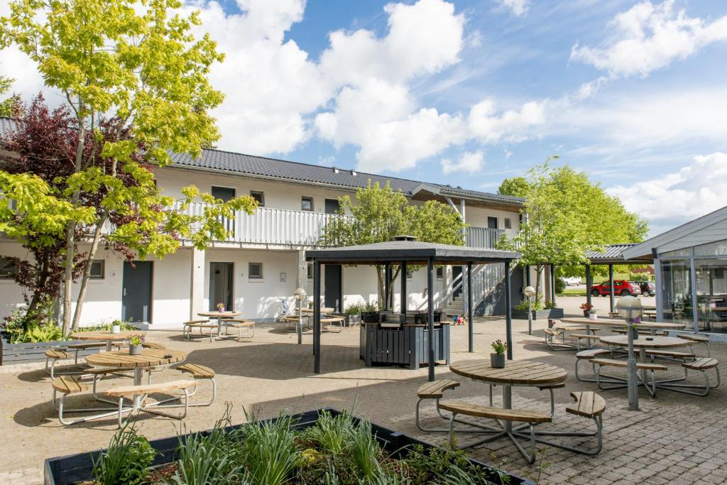 un grupo de mesas y bancos en un patio en Danhostel Vejle, en Vejle