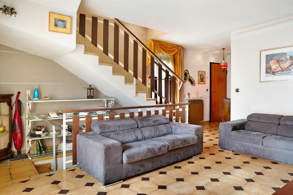 ein Wohnzimmer mit einem Sofa und einer Treppe in der Unterkunft Casa paradiso di montagna in Roccaforte Mondovì