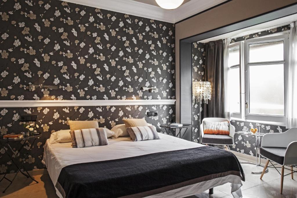 een slaapkamer met een bed en een muur bedekt met bloemen bij AinB B&B Eixample-Muntaner in Barcelona