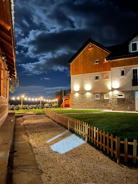 a building with a fence in front of it at night at Chestnut Hill in Kolgecaj