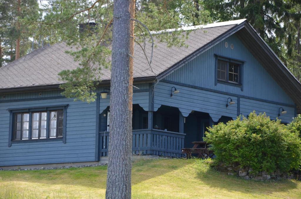 Niebieski dom z kijem przed nim w obiekcie Järvenrantamökki poreammeella 