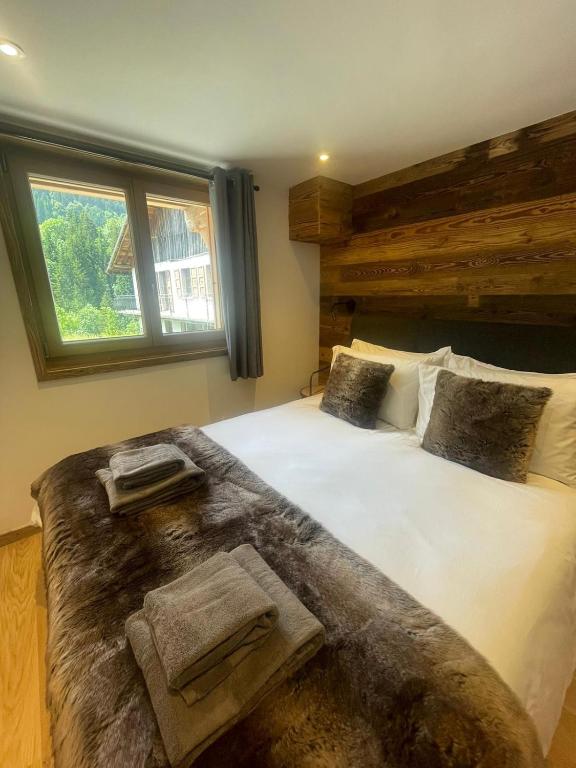 une chambre avec un grand lit avec deux serviettes dessus dans l'établissement Le Petit Cham - Cosy and Stylist with Balcony View, à Morzine