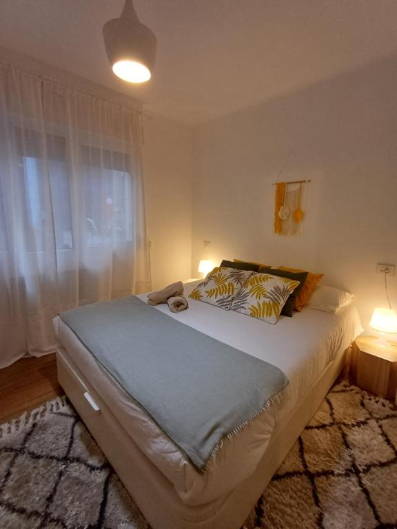 a bedroom with a large bed with two lamps at SWEET HOME BILBAO in Bilbao