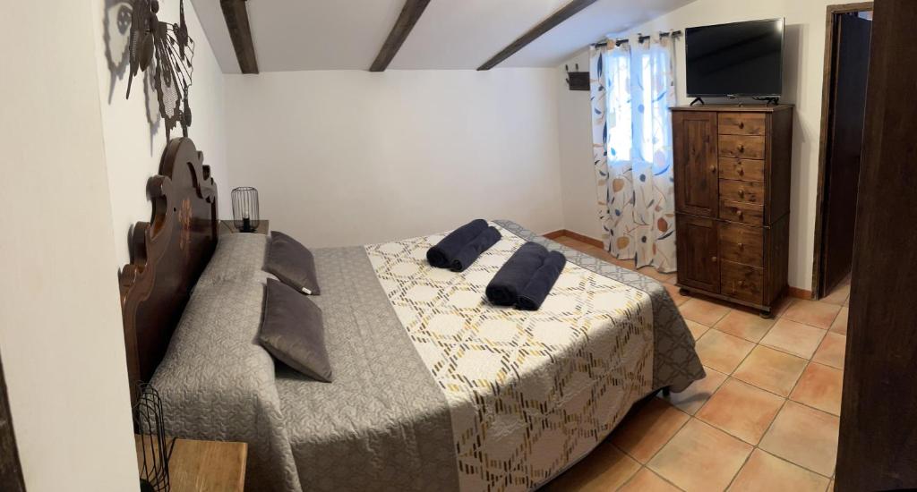 a bedroom with a bed and a dresser and a television at Esencia de Arcos in Arcos de la Frontera