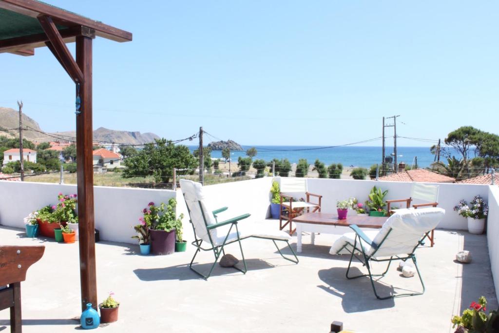 a patio with chairs and a table on a roof at Aumkara in Skala Eresou