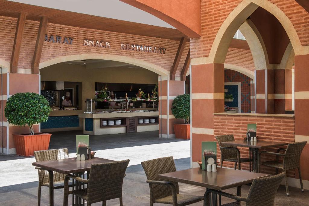 a patio with tables and chairs in a restaurant at Megasaray Club Belek in Belek